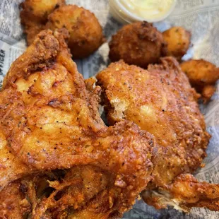 a basket of fried chicken with a side of dipping sauce