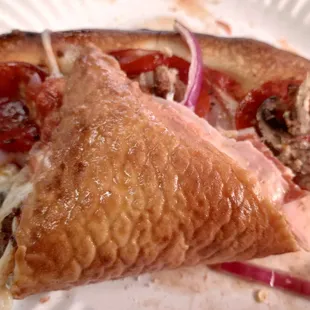 a slice of pizza on a paper plate