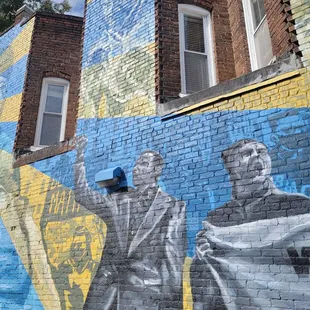 a mural of two men on the side of a building