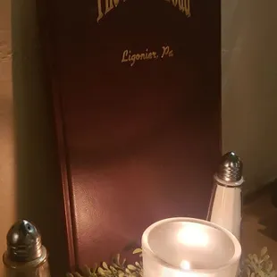 a lit candle and a book