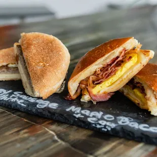 three sandwiches on a slate board