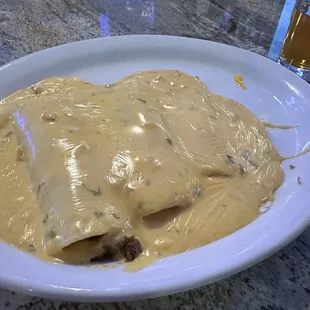 Carnitas and beef enchiladas smothered in queso