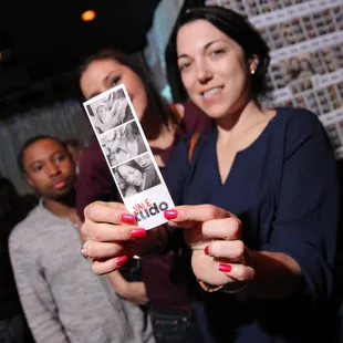 a woman holding up a photo of herself