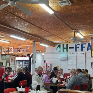 a group of people sitting at tables in a restaurant