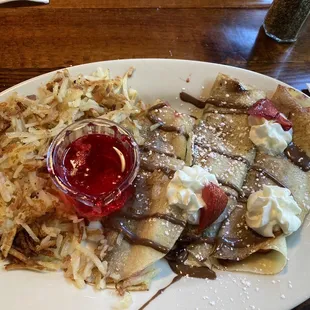 Nutella Crepes with strawberries, bananas, and strawberry syrup. Served with hash browns.
