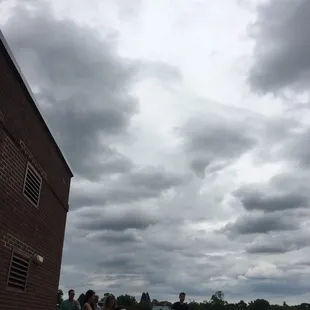 a group of people sitting and standing on the roof of a building