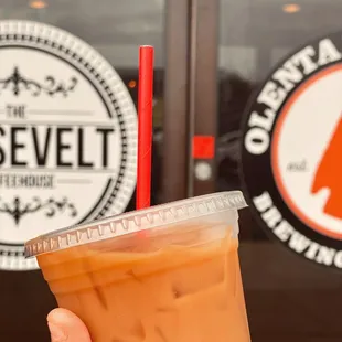 a hand holding a cup of iced coffee