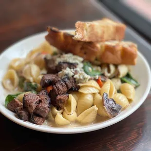 a plate of pasta with meat and vegetables