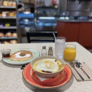 a breakfast of eggs, pancakes, and orange juice