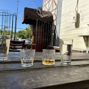 three glasses of whiskey on a wooden table