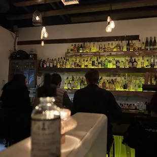 people sitting at a bar in a dimly lit room
