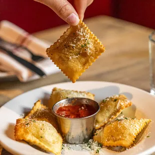 a person dipping some food into a bowl