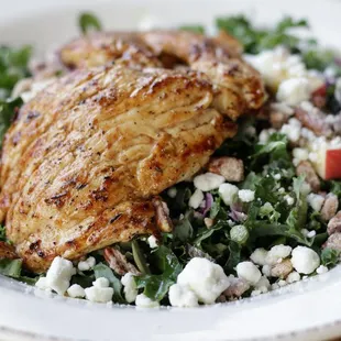 a white plate with a chicken and salad