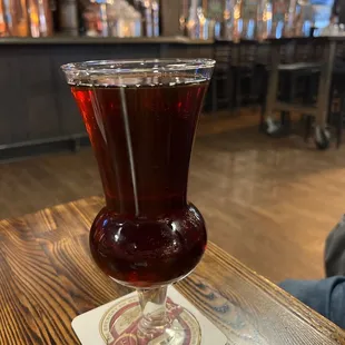 a glass of beer on a coaster