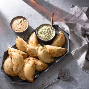 a plate of empanadas with dipping sauce
