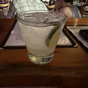 a glass of water with a lime slice in it