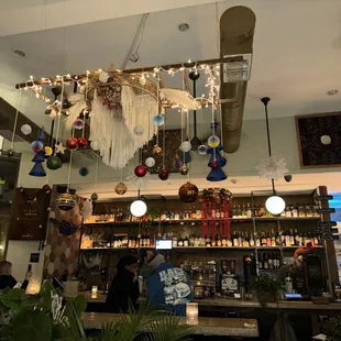 a bar with christmas decorations hanging from the ceiling