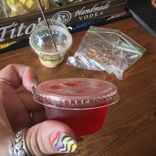 a person holding a plastic cup with a drink in it