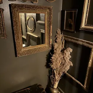 a vase of dried flowers in front of a mirror