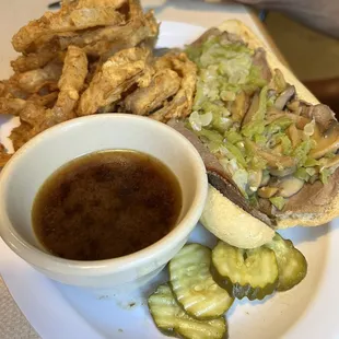 The Rustic Philly (served with au jus)  with onion rings.