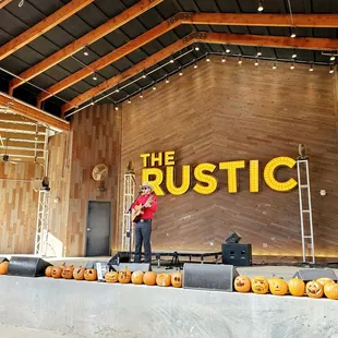 a man standing on a stage with carved pumpkins