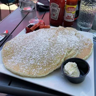 a plate of pancakes with butter and syrup