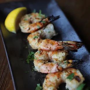 shrimp and rice on a black plate