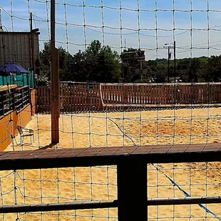 a fenced area with a volleyball court