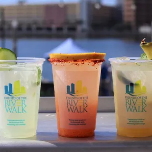 three different drinks in plastic cups