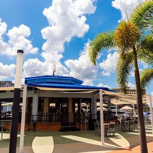a view of a restaurant with palm trees in the foreground