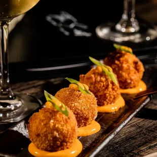 three appetizers and a glass of wine