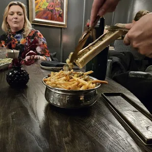 a woman serving french fries at a restaurant