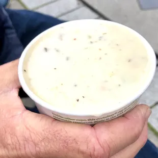 a person holding a bowl of soup