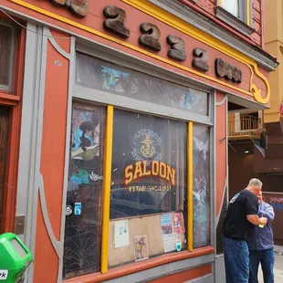 two men standing outside of a restaurant