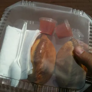 a hand holding a plastic container of food
