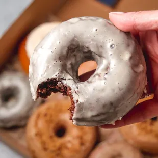 a hand holding a half eaten donut