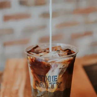 a person pouring milk into a cup