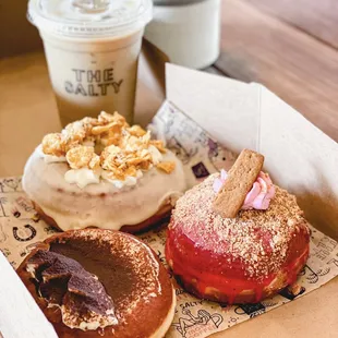 donuts clockwise: cornflake cereal milk and honey, dragon and passion fruit (seasonal), tiramisu, &amp; vanilla bean latte