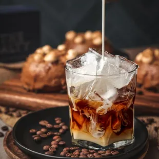 an iced coffee being poured into a glass