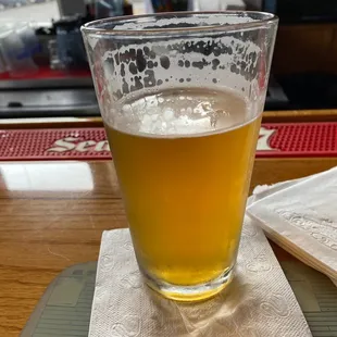 a glass of beer on a napkin
