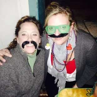 a woman with a fake moustache on her face and a woman with a fake moustache on her face