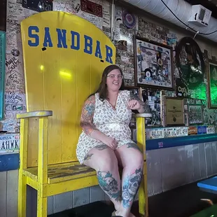 a woman sitting on a yellow bench