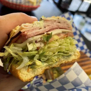 a hand holding a sandwich