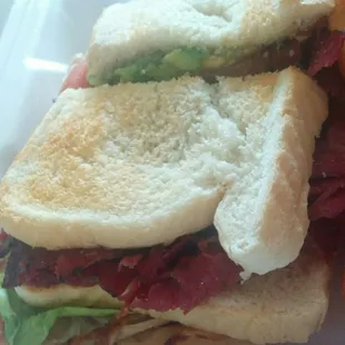 Triple decker,  up close.  Turkey,  fried pastrami and avocado.