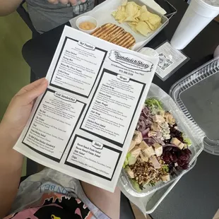 a person holding up a menu