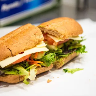 a sub sandwich with cheese, lettuce, tomato, and lettuce