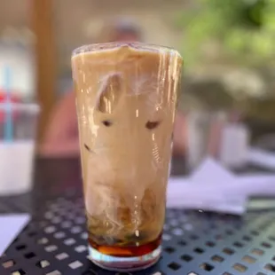 a glass of iced coffee on a table