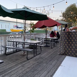 several tables and umbrellas on a deck
