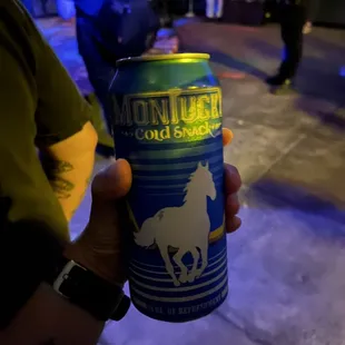 a person holding a can of beer