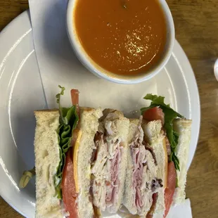 Half of a club sandwich and a cup of tomato basil soup!